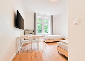 ein Wohnzimmer mit einem Tisch, Stühlen und einem Bett in der Unterkunft RAJ Living - 3 and 4 Room Apartments in Duisburg