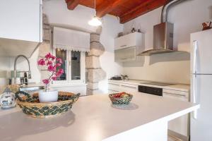 a kitchen with a counter with a bowl of fruit at Villa Veli Palac in Baška