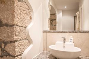 a bathroom with a sink and a stone wall at Villa Veli Palac in Baška