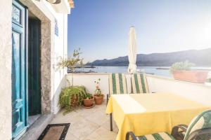 a table and chairs on a balcony with a view of the water at Villa Veli Palac in Baška