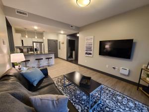a living room with a couch and a flat screen tv at 520 Neil Luxury 2 Bedroom in Champaign