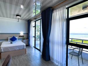 a bedroom with a bed and a view of the ocean at Galaxy Sunrise Sea View in Fulidhoo