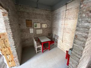 um pequeno quarto com uma mesa vermelha e cadeiras em Hostal Casa De Arcos em Puebla