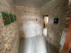 um quarto com paredes de tijolos e pinturas na parede em Hostal Casa De Arcos em Puebla