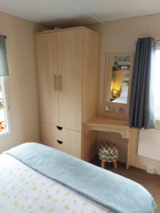 a bedroom with a bed and a dresser and a mirror at Betty's Place in Whitley Bay