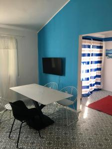 a table and chairs in a room with a blue wall at Land and Sea in Primošten