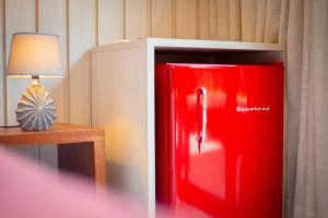 einem roten Kühlschrank neben einem Tisch mit einer Lampe in der Unterkunft Pousada Xica in Fernando de Noronha