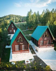 an overhead view of two log homes with a blue roof at Nicola’s hill in Žabljak