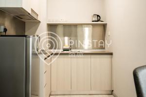a kitchen with a counter and a refrigerator at Jesselton Quay by Pinstay in Kota Kinabalu