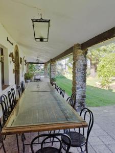 une grande table et des chaises sur la terrasse dans l'établissement La Casería, à Navaconcejo
