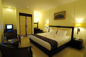 um quarto de hotel com uma cama e uma televisão em Luta Resort Toraja em Rantepao
