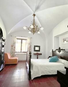 1 dormitorio con cama y lámpara de araña en La Casería, en Navaconcejo