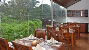 un restaurant avec des tables et des chaises et une grande fenêtre dans l'établissement Roseberry Villa, à Nuwara Eliya