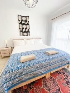 a bedroom with a bed with two pillows on it at Casa Lua Guesthouse in Burgau
