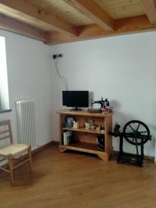 uma sala de estar com uma televisão e uma mesa com uma cadeira em Cà Giulia em Vignola