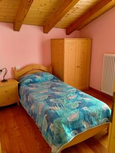 a bedroom with a bed with a blue comforter at Cà Giulia in Vignola