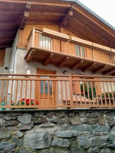 - un balcon en bois sur une maison avec un mur en pierre dans l'établissement Cà Giulia, à Vignola