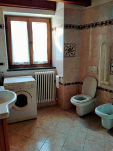 a bathroom with a washing machine and a toilet at Cà Giulia in Vignola