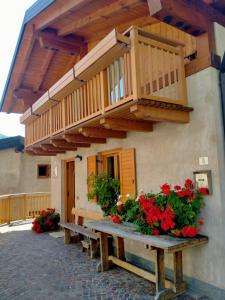 eine Veranda mit einem Holztisch mit Blumen und einem Balkon in der Unterkunft Cà Giulia in Vignola