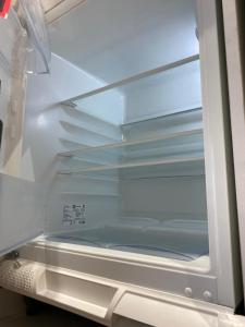 an empty refrigerator door is open with a drawer at Aktau Riviera in Aktau