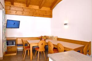 una sala da pranzo con tavolo e sedie in legno di Appartements neben der Gondelbahn - Haus Süd a Brixen im Thale