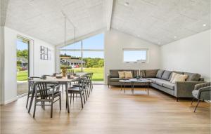 uma sala de estar com um sofá, uma mesa e cadeiras em 4 Bedroom Pet Friendly Home In Hadsund em Hadsund