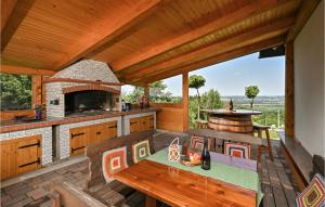 eine Außenküche mit einem Tisch und Stühlen auf einer Terrasse in der Unterkunft Lovely Home In Veliki Lovrecan With House A Panoramic View in Veliki Lovrečan
