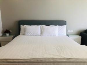 a large bed with white sheets and pillows at Luxury studio apartment near Nha Trang beach in Nha Trang