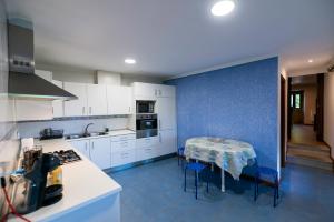 a kitchen with a table and a blue wall at A Bruxiña de Toldaos in Pantón