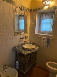 een badkamer met een wastafel, een toilet en een spiegel bij B&B Il Casale Del Ginepro in Migliano