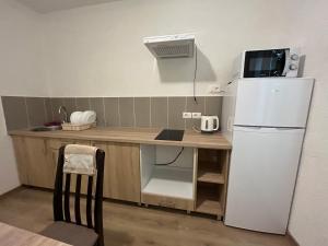 a small kitchen with a white refrigerator and a table at SeaAdrik in Bar