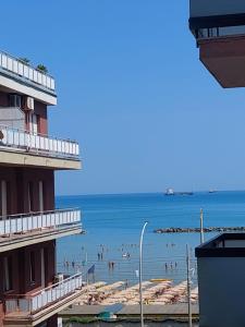 een uitzicht op een strand met mensen in het water bij appartamento fronte mare in Falconara Marittima