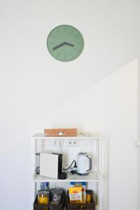 a clock on a wall above a shelf with food at Casa Pesa 2 rooms 2 baths Rome center in Rome