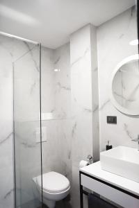 a white bathroom with a toilet and a sink at Elite estate in Podstrana