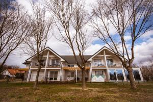 a white house with trees in front of it at Apartma Sofija, Moravski Dvori in Moravske Toplice