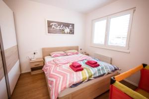 Un dormitorio con una cama con toallas rojas. en Apartma Sofija, Moravski Dvori en Moravske-Toplice