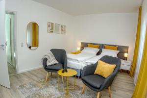 a bedroom with a bed and two chairs and a table at Appartement mit Balkon Westfalenhalle und Universität fußläufig in Dortmund