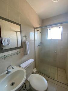 a bathroom with a toilet and a sink and a shower at Hotel Blanner in Charqueadas