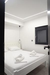 a bedroom with a white bed with towels on it at Elite estate in Podstrana
