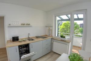 a white kitchen with a sink and a window at Appartement mit Balkon Westfalenhalle und Universität fußläufig in Dortmund