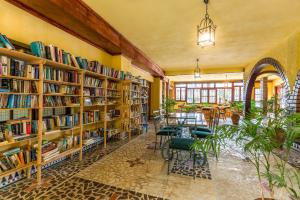 a library with wooden shelves filled with books at Hotel Molino De Saydo in Mollina