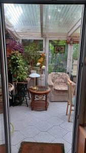 a porch with a table and a couch and some plants at Zimmer mit optimaler Verkehrsanbindung und vielen Extras in Berlin-Rudow in Berlin