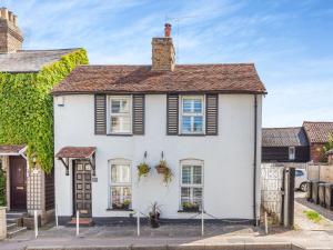 a white house with a brown roof at Cutters Cottage in Roydon