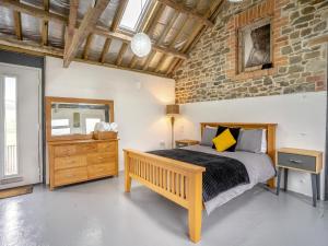 a bedroom with a bed and a stone wall at The Studio - Uk44779 in Hoel-galed