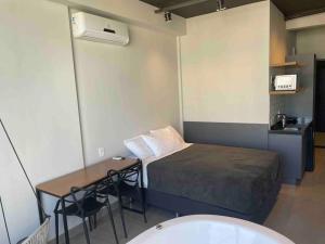 a small room with a bed and a desk and a table at Sky Loft - Andar 41 in Sao Paulo