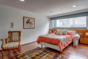 1 dormitorio con 1 cama, 1 silla y 1 ventana en Campos Eliseos - Luxurious PH with Private Jacuzzi Located in Polanco en Ciudad de México