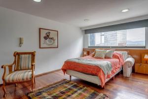 1 dormitorio con 1 cama, 1 silla y 1 ventana en Campos Eliseos - Luxurious PH with Private Jacuzzi Located in Polanco, en Ciudad de México