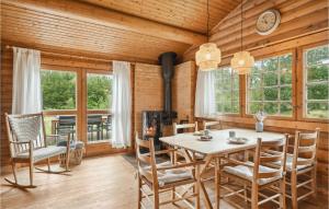 ein Esszimmer mit einem Tisch, Stühlen und Fenstern in der Unterkunft Lovely Home In Hjslev With Kitchen in Lundø