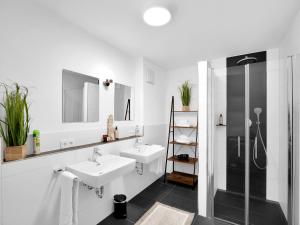 a white bathroom with two sinks and a shower at INhome 3x TV - Terrasse - Küche - Parken- Netflix in Crailsheim
