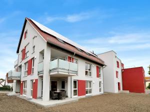 a white and red building with a balcony at INhome 3x TV - Terrasse - Küche - Parken- Netflix in Crailsheim